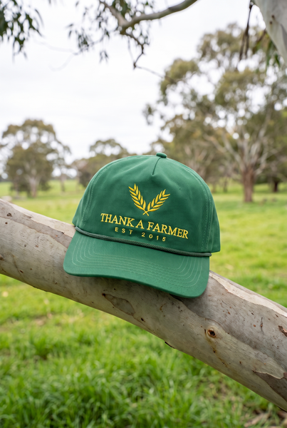 Green rope cap with yellow wheat emblem on gum branch