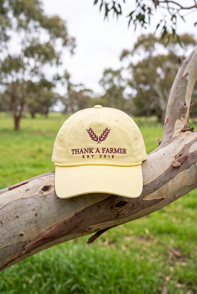 Butter yellow rope cap with maroon wheat emblem on gum branch